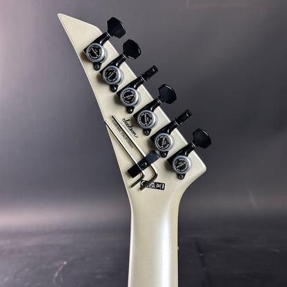 Guitar headstock with tuning pegs on a gray background