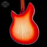 Close-up of the back of an electric guitar body showing a sunburst finish that fades from bright red-orange to a warm natural wood tone, set against a solid black background with a Tone Shop watermark in the top-left corner.