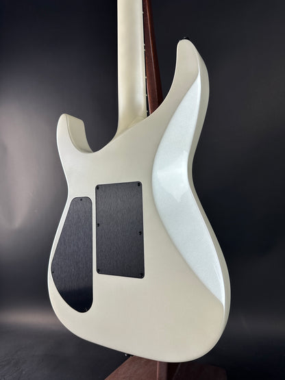 Close-up of a white electric guitar body on a dark background