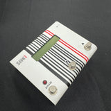 Guitar effects pedal with striped design on a black background