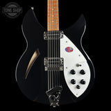 A black electric guitar with a white pickguard, maple neck, and chrome hardware, photographed against a solid black background. A Tone Shop watermark is visible in the top-left corner.