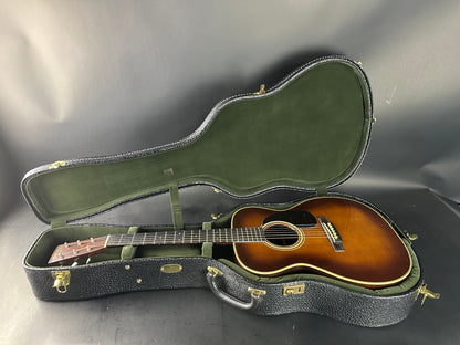 Acoustic guitar in a green case on a gray background
