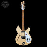 A natural wood electric guitar with a white pickguard and black hardware, shown against a solid black background. A Tone Shop watermark is visible in the top-left corner.