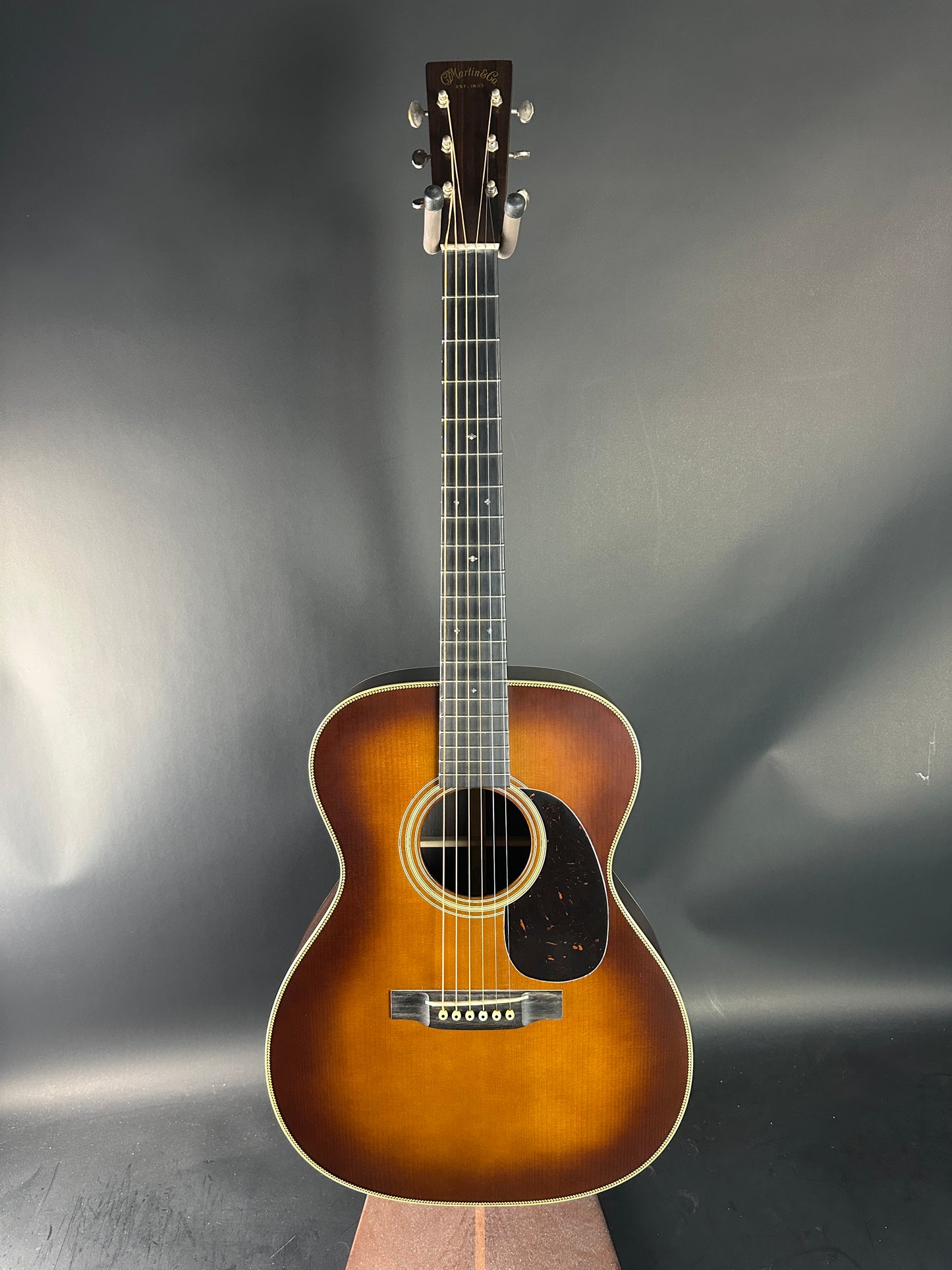 Acoustic guitar on a reflective gray surface