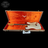 Electric guitar in an open case with a visible brand logo on a black background