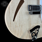Close-up of a light natural wood electric guitar body with chrome hardware, including a humbucker pickup, bridge, and tailpiece, shown against a black background. A Tone Shop watermark is visible in the top-left corner.