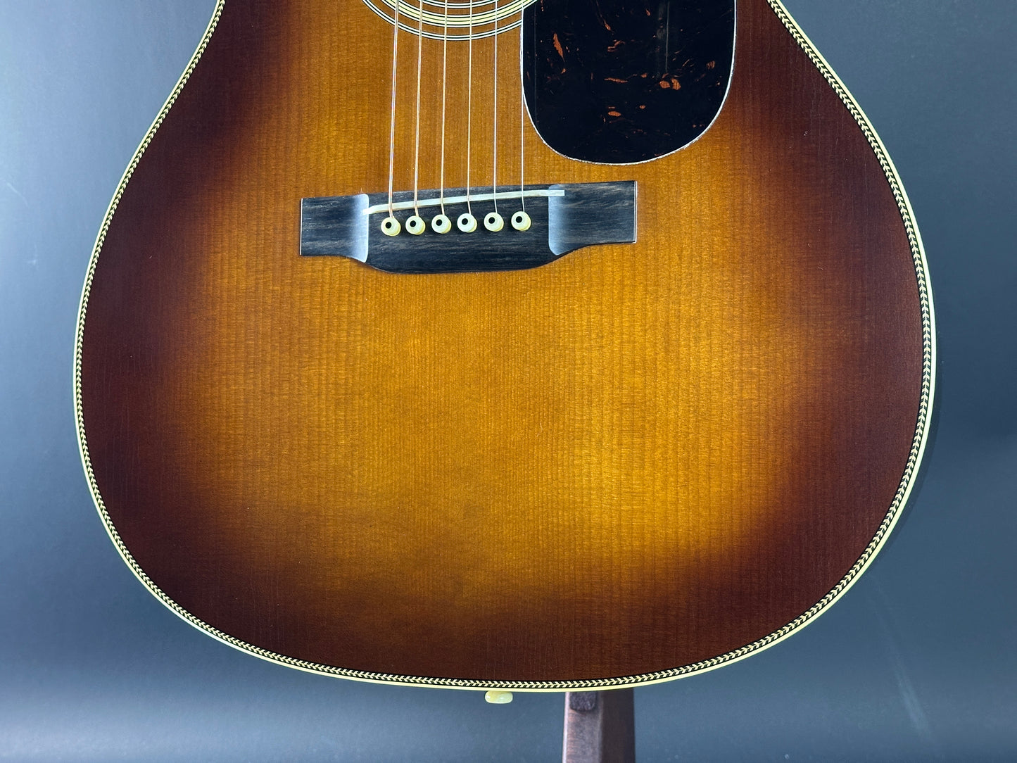 Close-up of an acoustic guitar's soundhole on a blue background