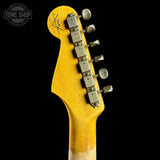 Close-up of a guitar headstock with tuning pegs on a black background, featuring the Fender logo.