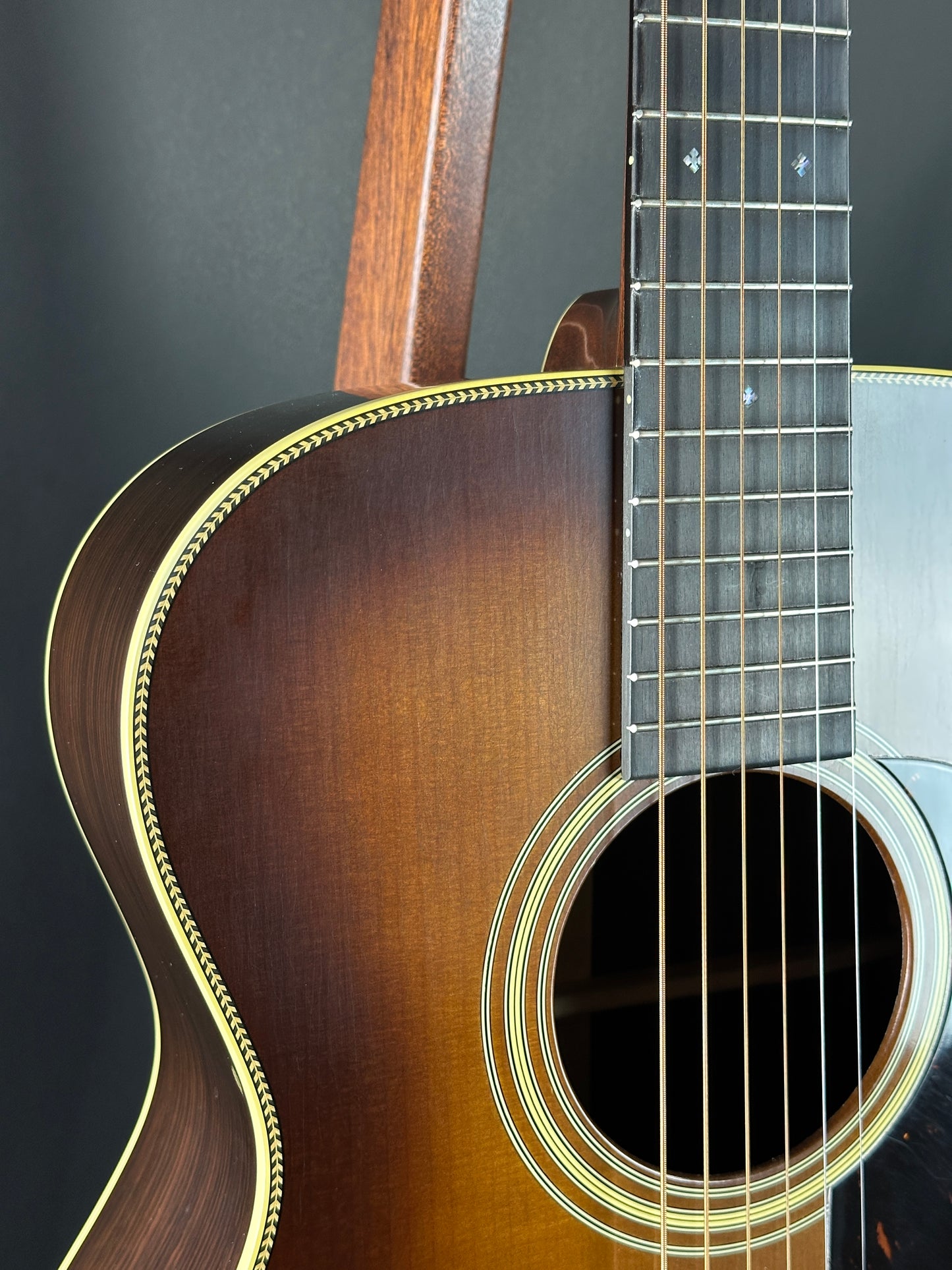 Close-up of an acoustic guitar's body and neck on a dark background