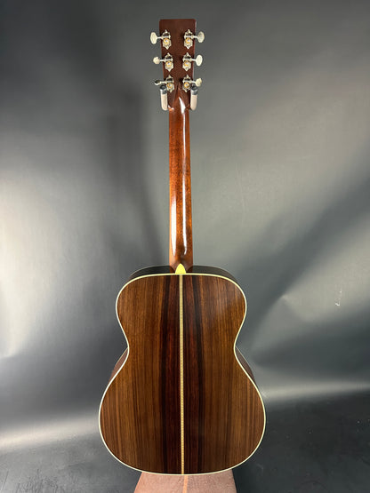 Wooden acoustic guitar on a reflective gray surface