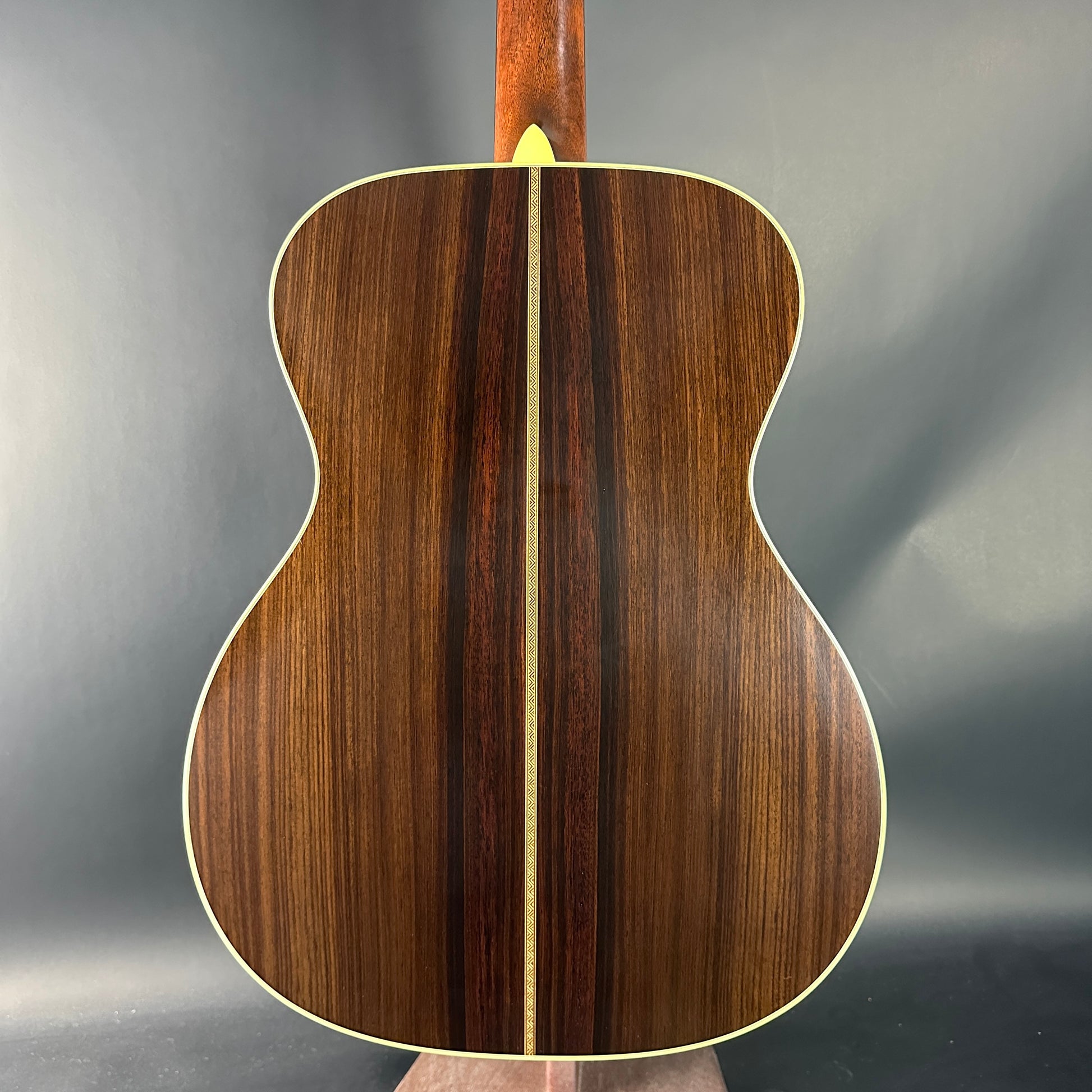 Wooden acoustic guitar back on a gray background