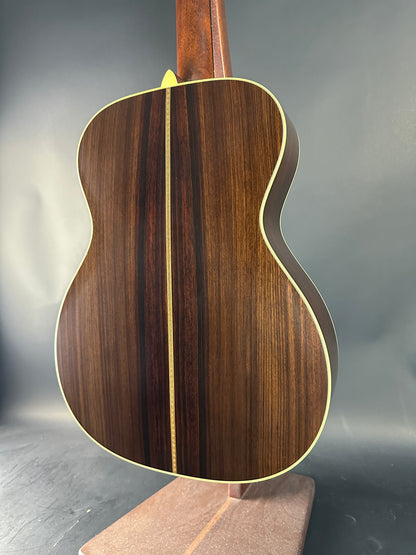 Close-up of a wooden acoustic guitar body on a gray background