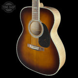 A close-up of an acoustic guitar body showing a classic sunburst finish that transitions from dark brown to warm amber, with a black pickguard and light natural wood sides, set against a solid black background.