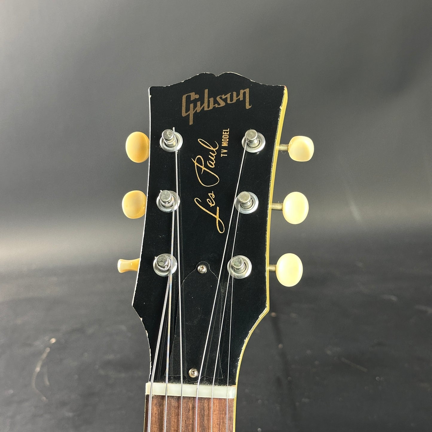 Gibson Les Paul guitar headstock on a dark background
