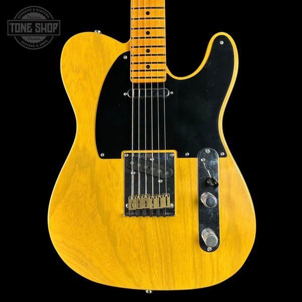 Yellow electric guitar with a black pickguard on a black background, featuring 'Tone Shop' branding.
