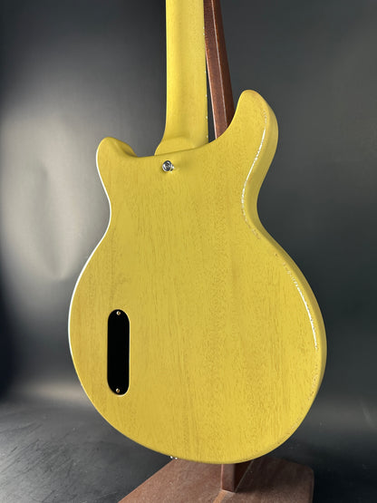 Close-up of a yellow electric guitar body on a dark background