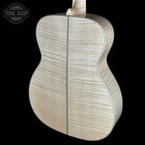 The back of an acoustic guitar made of light-colored flamed maple wood, showing a prominent grain pattern and a center seam, set against a solid black background with a Tone Shop logo in the top-left corner.