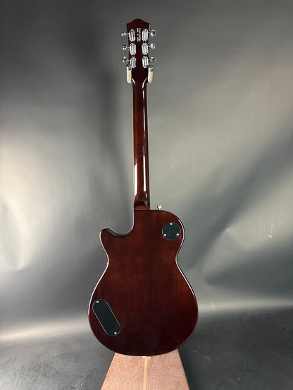 Brown electric guitar on a reflective gray surface