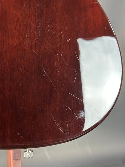 Close-up of a guitar's back with visible scratches on the wood.