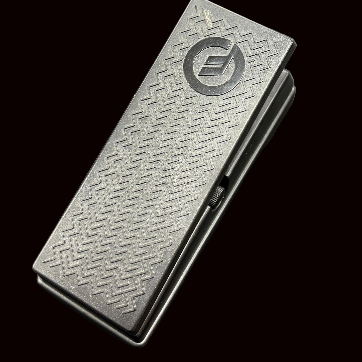 Metal wallet with embossed design and logo on a dark surface