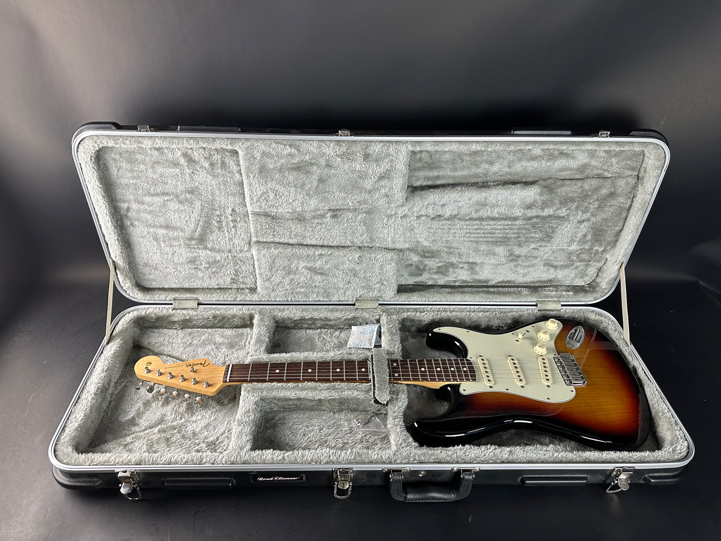 Electric guitar in a hard-shell case on a dark background