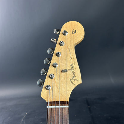 Close-up of a guitar headstock with Fender logo on a dark background