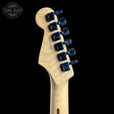 Close-up of a guitar headstock with a natural maple wood finish and black tuning pegs, shown against a black background with a Tone Shop watermark in the top left corner.