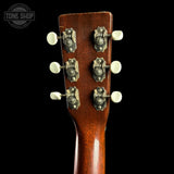 Close-up of a guitar headstock with tuning pegs on a black background, featuring 'Tone Shop' branding.