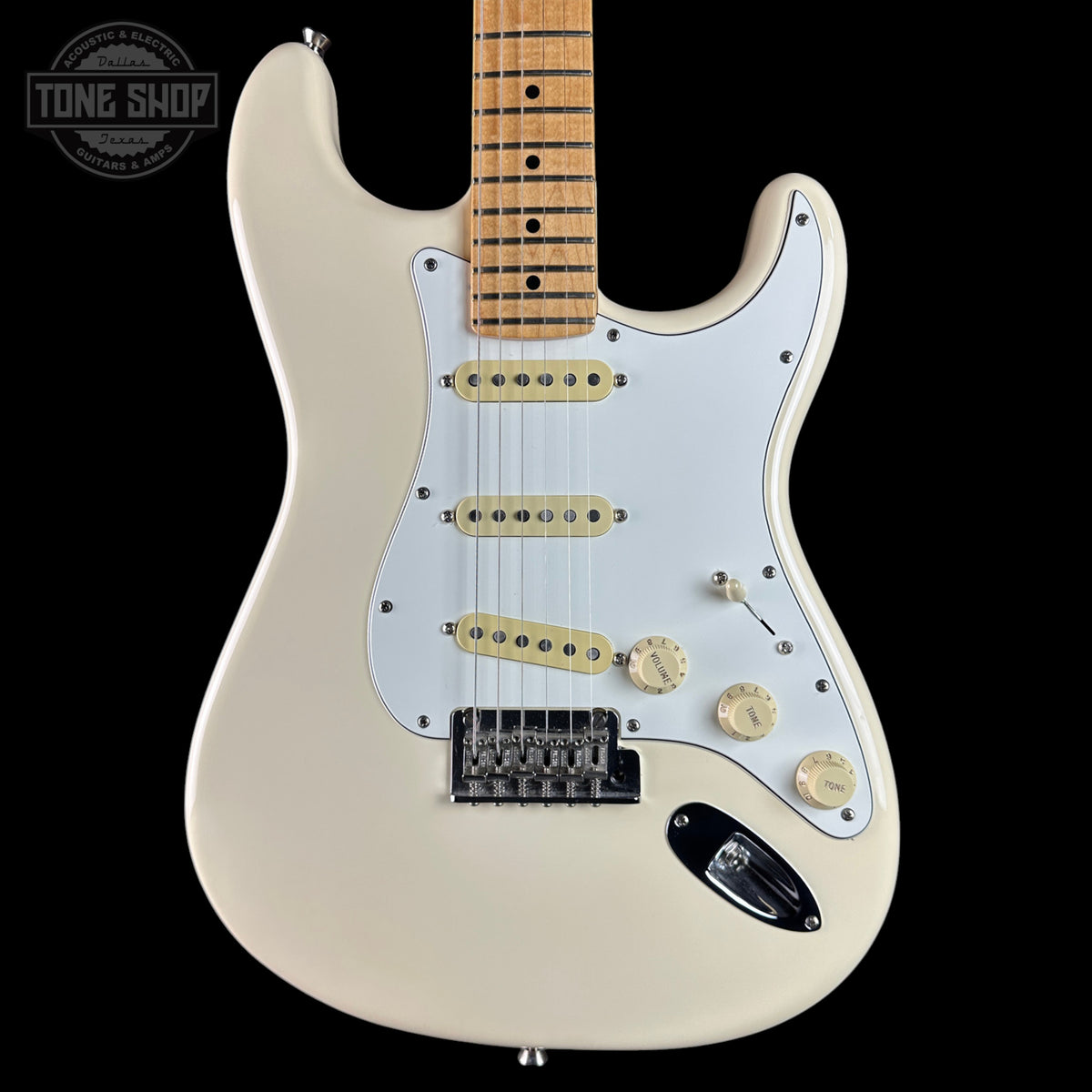 A classic electric guitar with a cream-colored body, white pickguard, and maple neck, shown against a solid black background. A 'Tone Shop' watermark is visible in the top left corner.