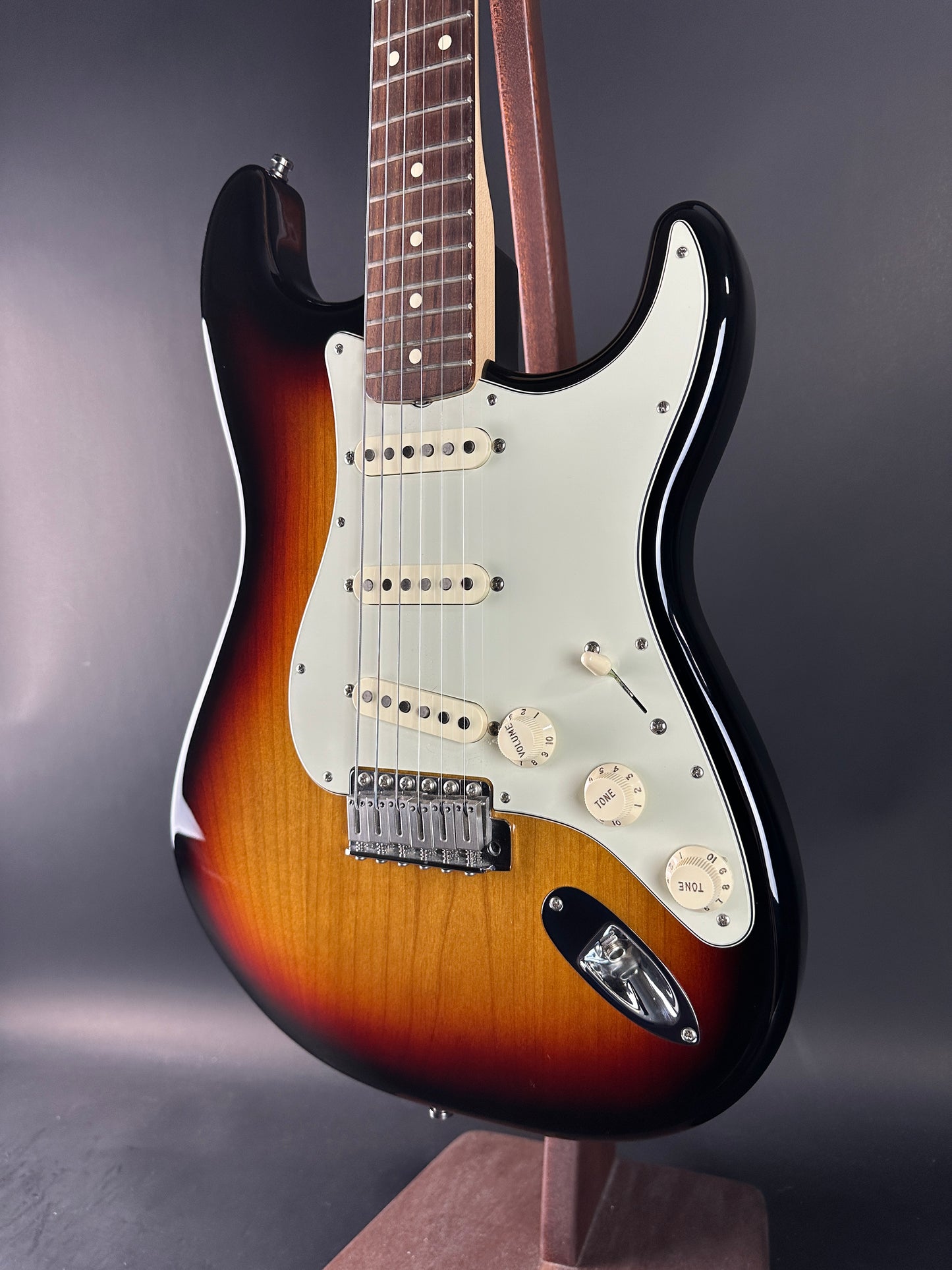 Fender Stratocaster guitar with a sunburst finish on a dark background