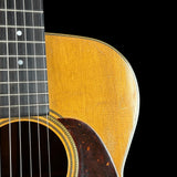 Close-up of an acoustic guitar's neck and soundhole on a black background