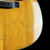 Close-up of a wooden acoustic guitar with a black pickguard on a white background