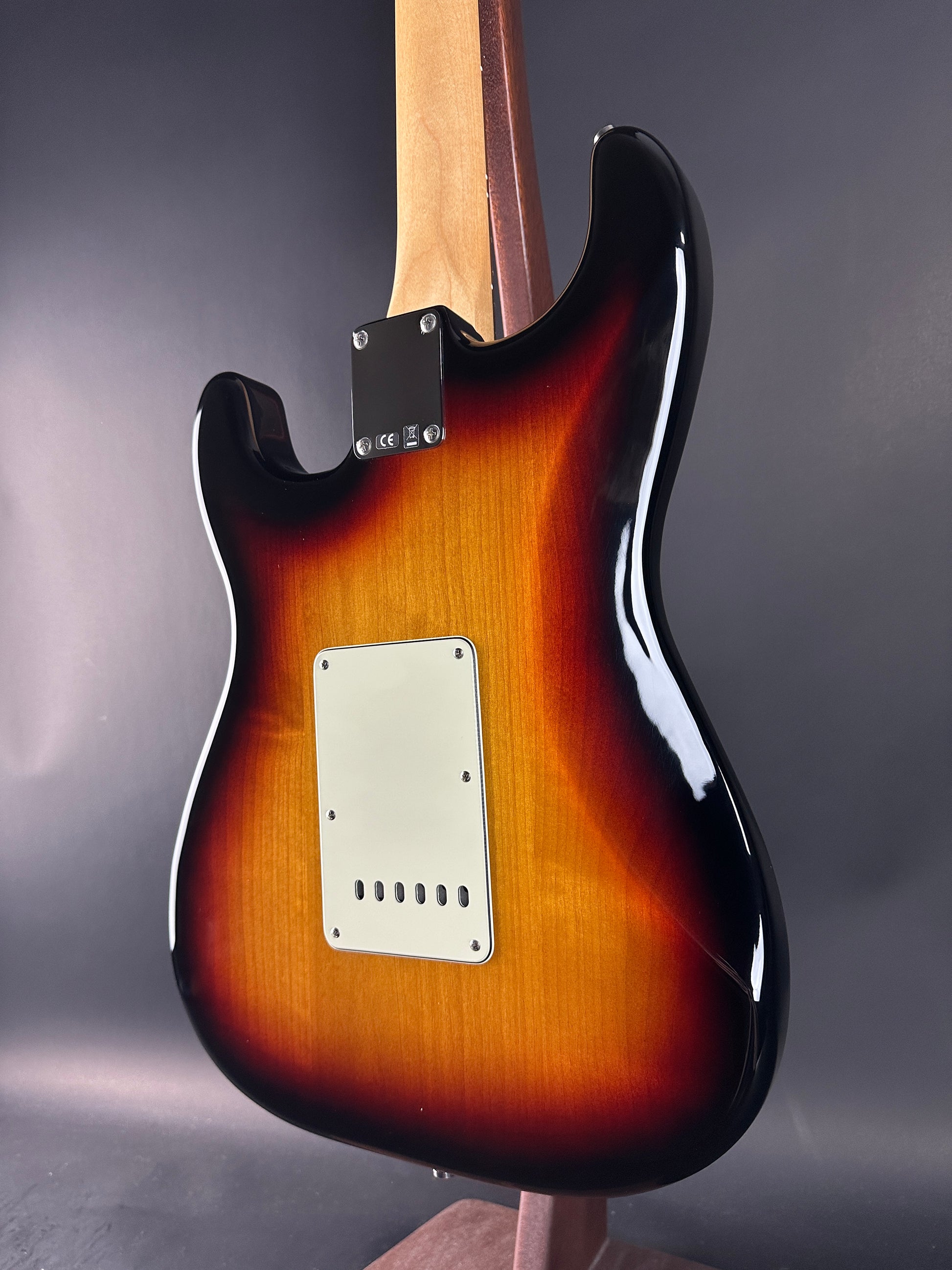 Glossy electric guitar body with sunburst finish on a dark background