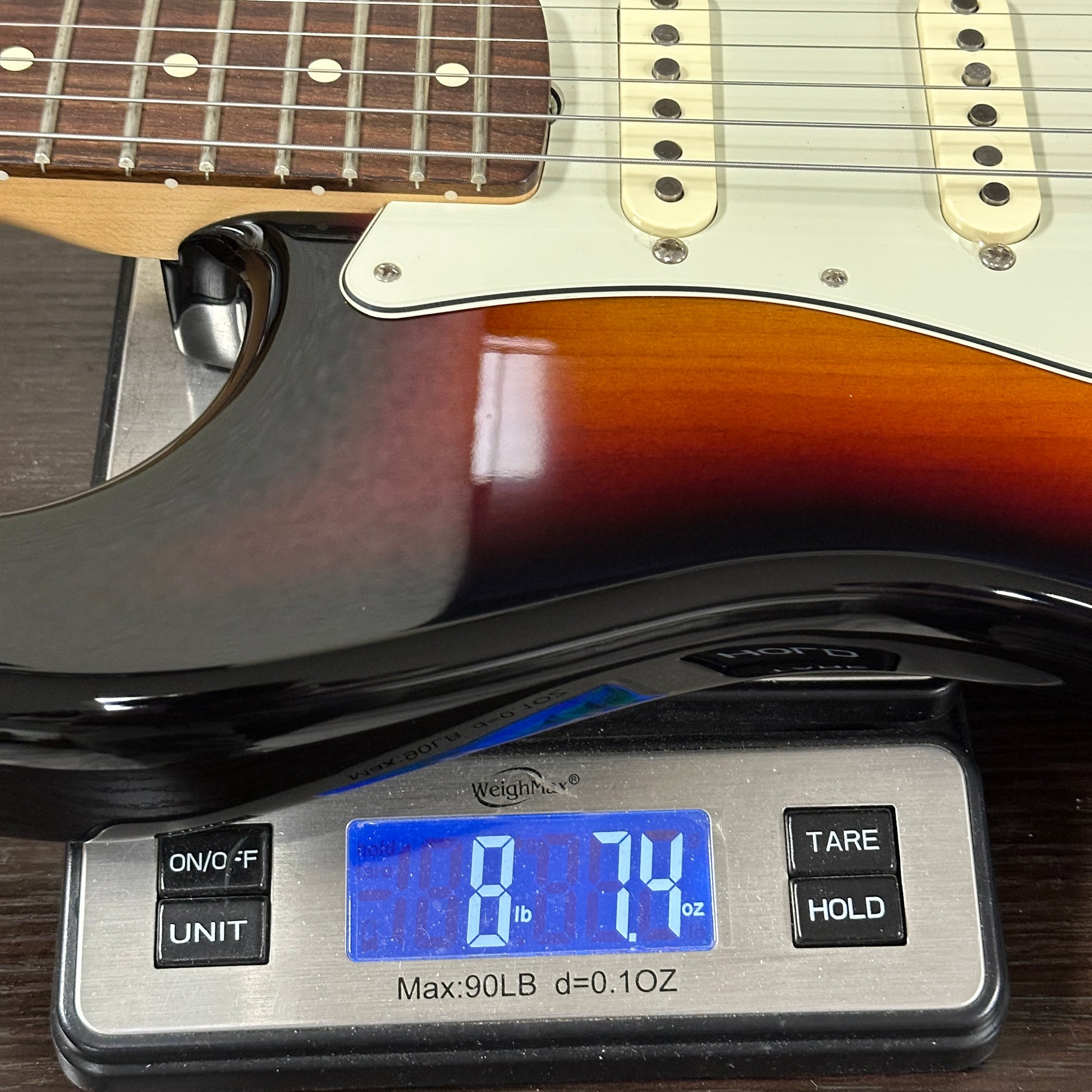 Guitar on a digital scale displaying weight