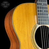 Close-up of a wooden acoustic guitar with a black background