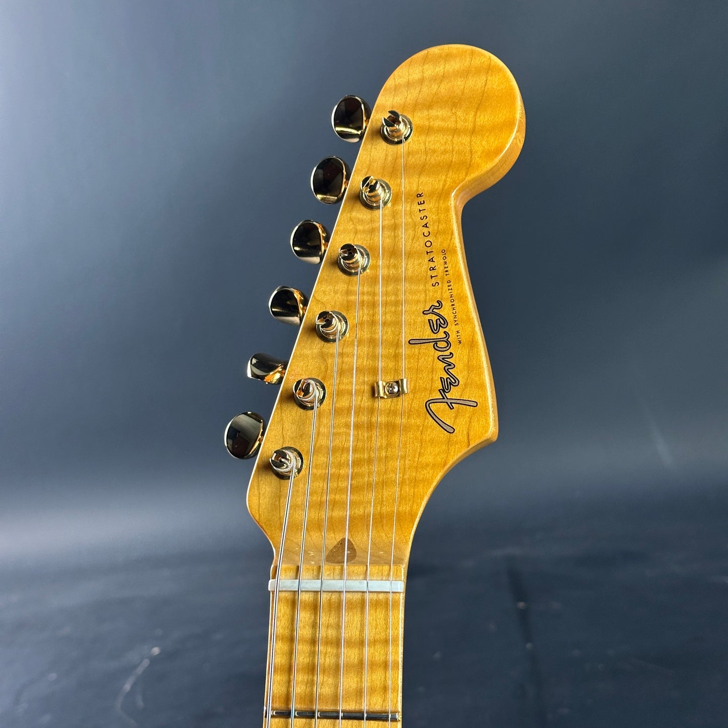 Close-up of a Fender guitar headstock on a dark background