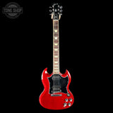 A red electric guitar with a black pickguard and chrome hardware, shown vertically against a solid black background. A Tone Shop watermark is visible in the top-left corner.