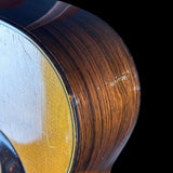 Close-up of a guitar's soundhole and wooden body on a black background