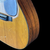 Close-up of a wooden acoustic guitar on a black background
