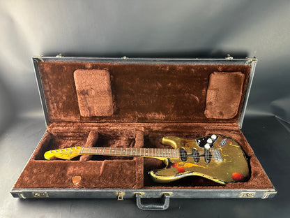 Guitar in an open brown case on a gray background