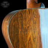 Close-up of a wooden guitar neck with 'Tone Shop' logo in the corner.