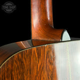 Close-up of a guitar's wooden neck and body with 'Tone Shop' branding.