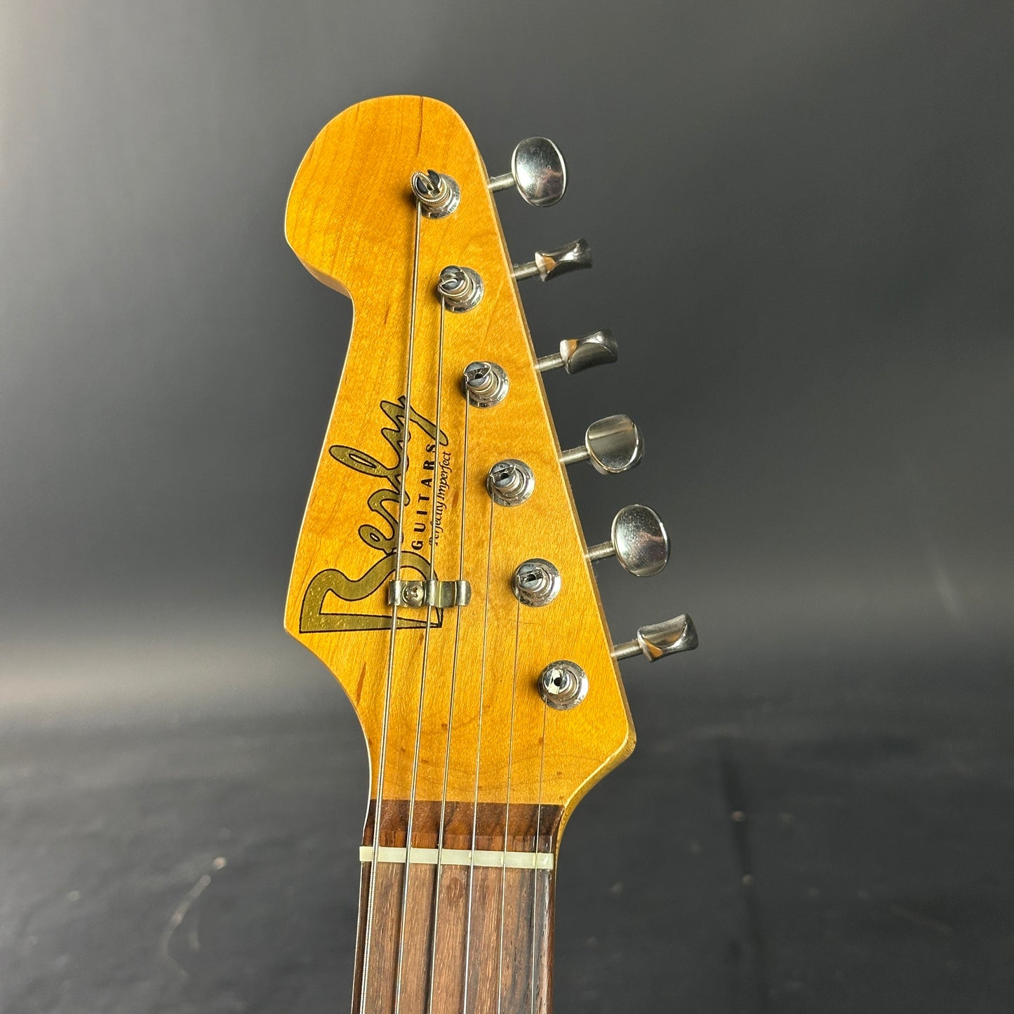 Guitar headstock with 'Reverend' branding on a dark background