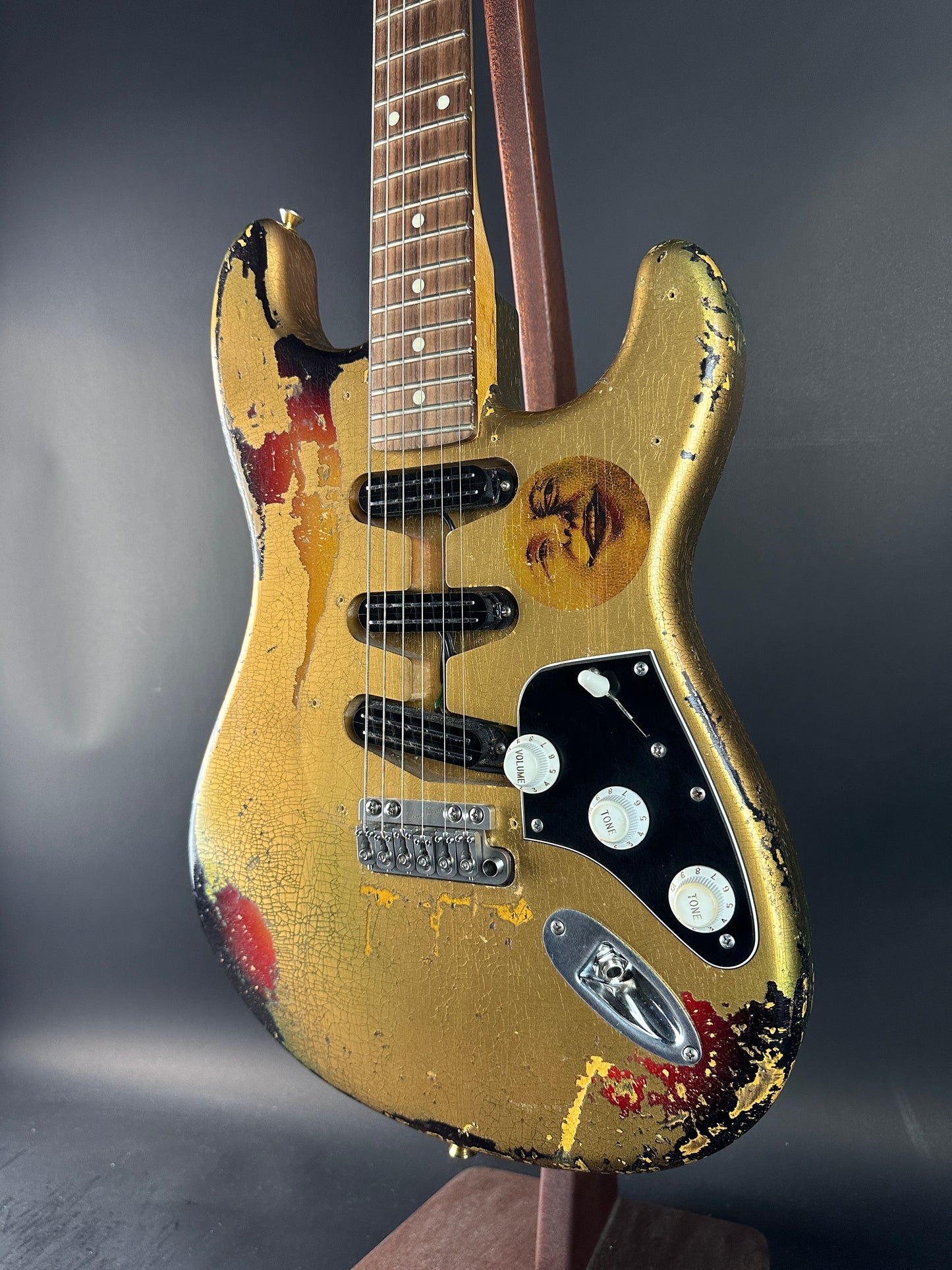 Worn electric guitar with visible wear and tear on a dark background