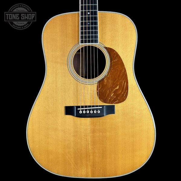 A front-facing acoustic guitar with a natural wood finish and dark fretboard, shown against a solid black background with a Tone Shop watermark in the top-left corner.