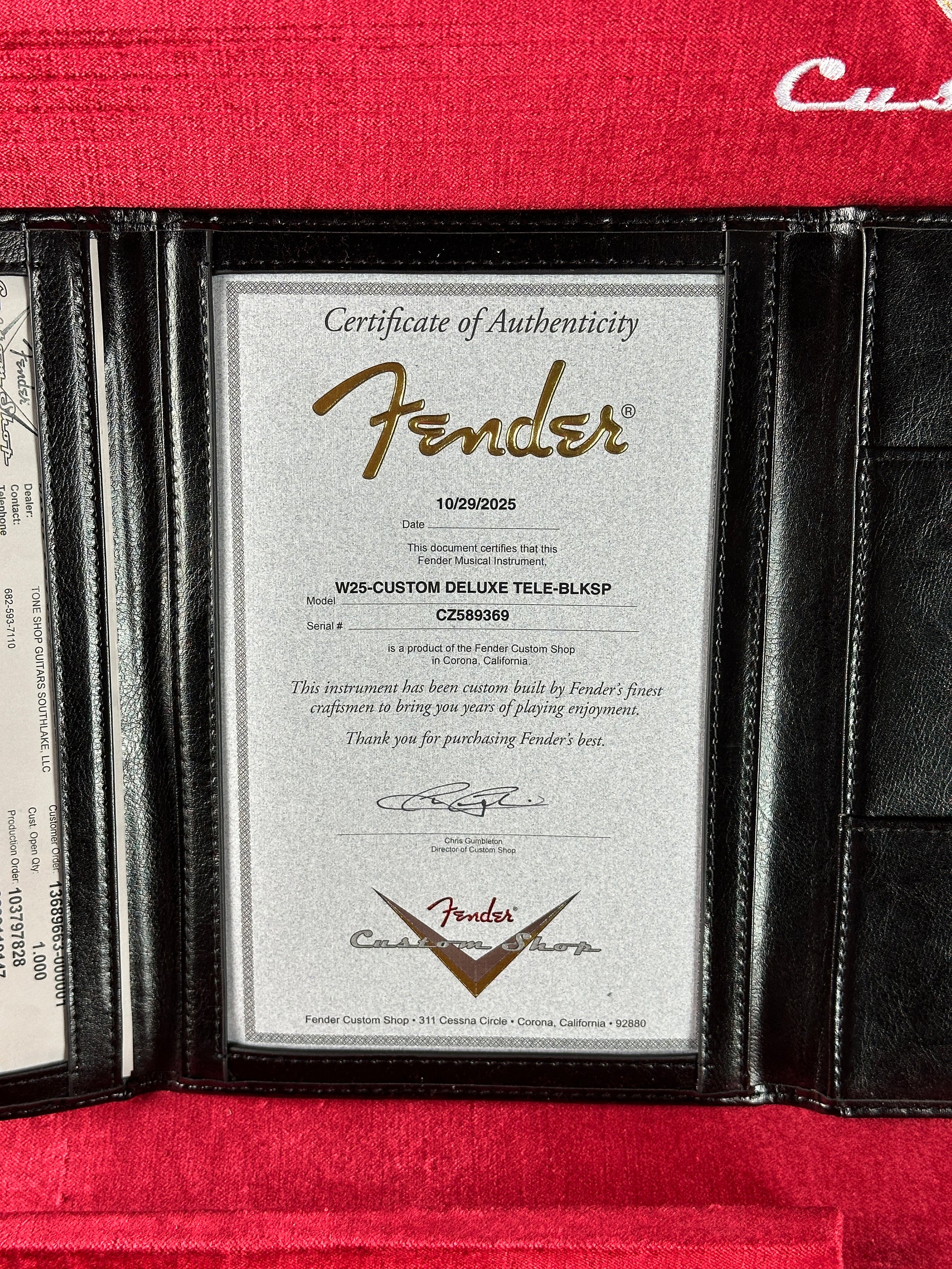 Fender certificate of authenticity inside a black leather wallet on a red background