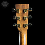Close-up of a guitar headstock with tuning pegs on a black background, featuring 'Tone Shop' branding.