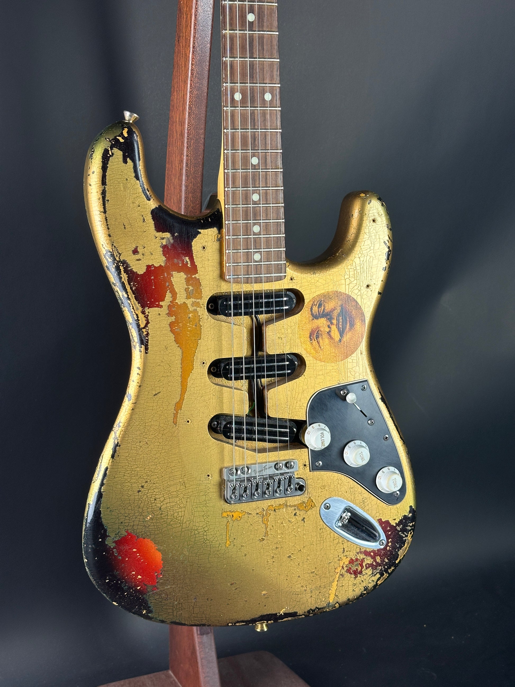 Worn electric guitar with visible wear and tear on a dark background