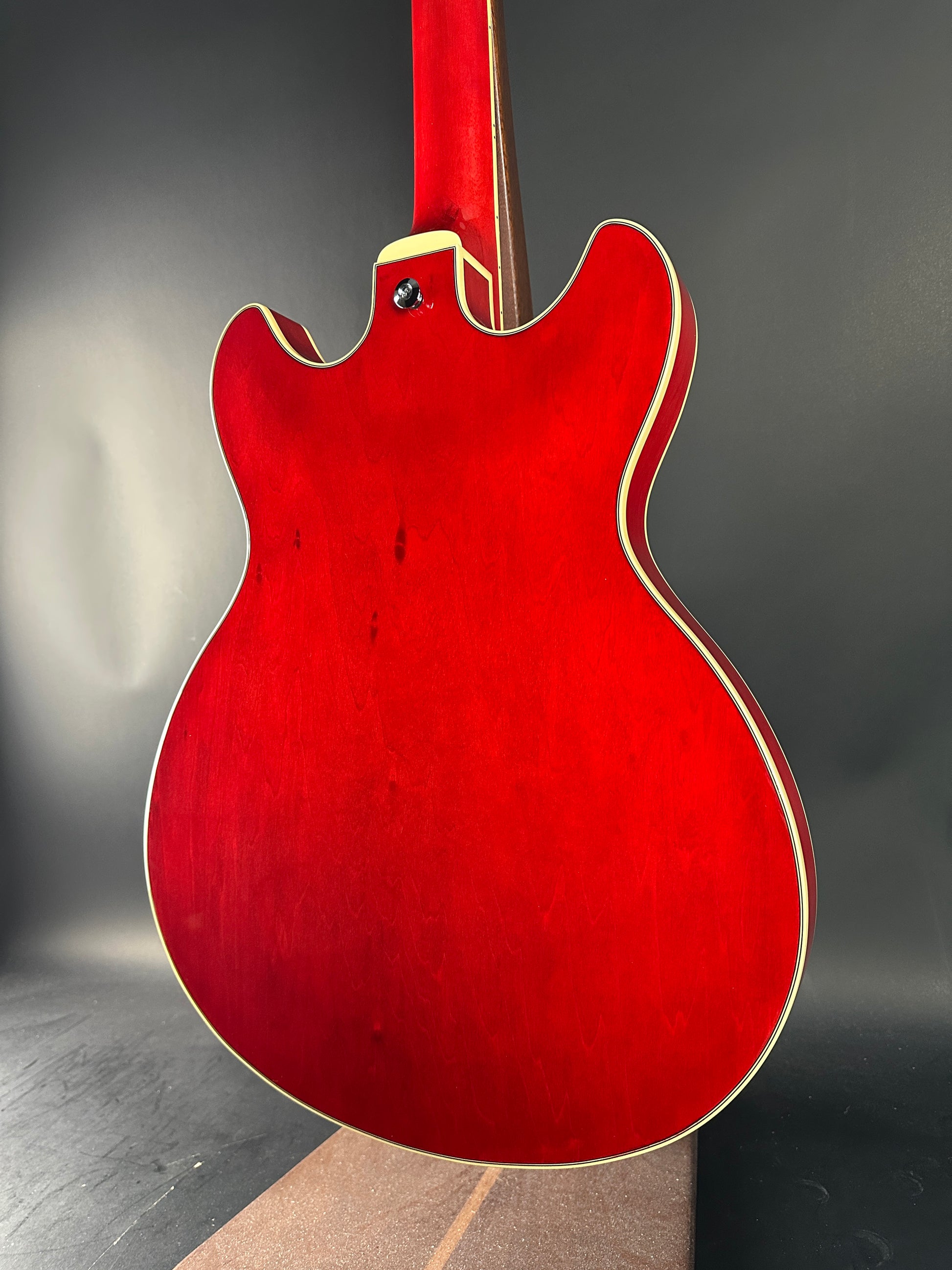 Red electric guitar on a dark surface