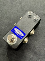 Black metal switch with screws on a gray background